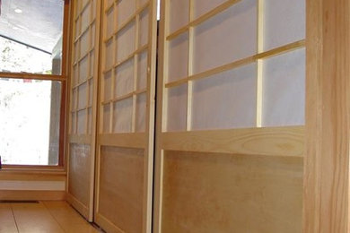 Diseño de armario unisex de estilo zen de tamaño medio con armarios con paneles empotrados, puertas de armario de madera clara y suelo de madera clara