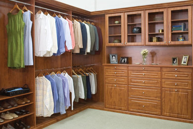 Mid-sized elegant gender-neutral walk-in closet photo in Orange County with raised-panel cabinets and medium tone wood cabinets