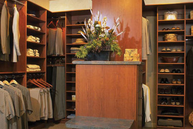 Modelo de armario vestidor de hombre tradicional renovado de tamaño medio con armarios con paneles lisos, puertas de armario de madera oscura y moqueta