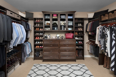 Example of a classic closet design in Other with dark wood cabinets