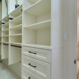 Immagine di una cabina armadio unisex tradizionale di medie dimensioni con ante con bugna sagomata, ante bianche, moquette e pavimento bianco