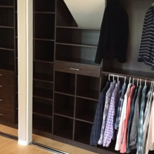 Immagine di un armadio o armadio a muro unisex contemporaneo di medie dimensioni con ante lisce, ante in legno bruno, pavimento in bambù e pavimento beige