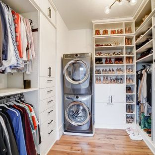 Diseño de armario vestidor unisex, clásico renovado, con armarios con paneles lisos, puertas de armario blancas, suelo de madera en tonos medios y suelo marrón