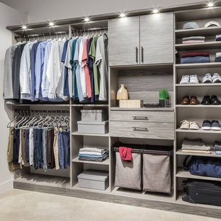 Cette photo montre un grand dressing tendance pour un homme avec un placard sans porte, des portes de placard grises, un sol en bois clair et un sol beige.