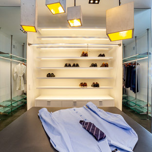 Ejemplo de vestidor unisex, moderno, extra grande, con armarios con paneles lisos, puertas de armario azules, suelo de cemento y suelo gris