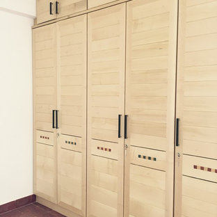 Esempio di armadi e cabine armadio eclettici di medie dimensioni con ante con riquadro incassato e ante in legno chiaro