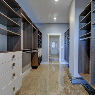Foto di una grande cabina armadio unisex contemporanea con ante lisce, ante bianche, pavimento in cemento e pavimento beige