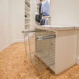 Idee per una cabina armadio unisex industriale con nessun'anta, ante bianche, pavimento in sughero e pavimento beige