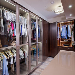 Diseño de vestidor unisex, contemporáneo, pequeño, con armarios tipo vitrina, puertas de armario de madera en tonos medios, suelo de madera clara y suelo gris