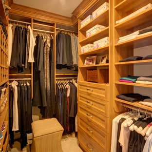 Modelo de armario vestidor unisex, tradicional, de tamaño medio, con armarios abiertos, puertas de armario de madera clara, moqueta y suelo beige