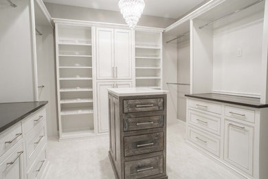 Diseño de armario y vestidor clásico con armarios con rebordes decorativos, puertas de armario blancas, moqueta y suelo blanco