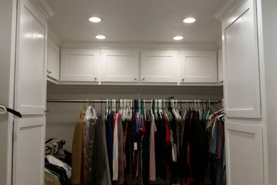 Example of a large classic gender-neutral walk-in closet design in Austin with shaker cabinets and white cabinets