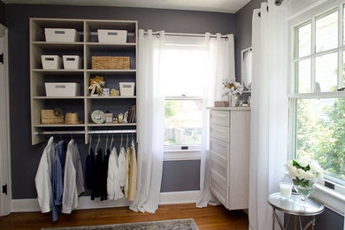 Example of a mid-sized classic women's medium tone wood floor dressing room design in Indianapolis with open cabinets and white cabinets