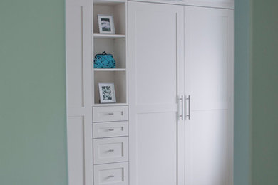 Imagen de armario y vestidor clásico renovado con armarios estilo shaker, puertas de armario blancas y suelo de madera clara