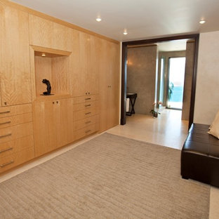 Ejemplo de vestidor tropical, grande, con armarios con paneles lisos y puertas de armario de madera clara