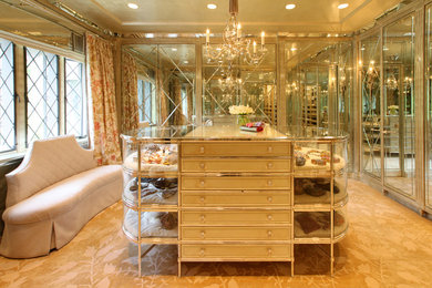Huge elegant women's carpeted walk-in closet photo in New York with glass-front cabinets