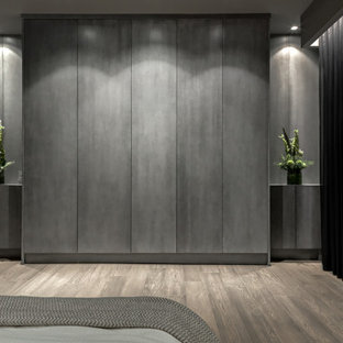 Immagine di un grande armadio incassato contemporaneo con ante lisce, ante in legno bruno e parquet chiaro
