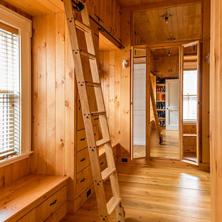 Ispirazione per una grande cabina armadio unisex tradizionale con ante in legno scuro e pavimento in legno massello medio