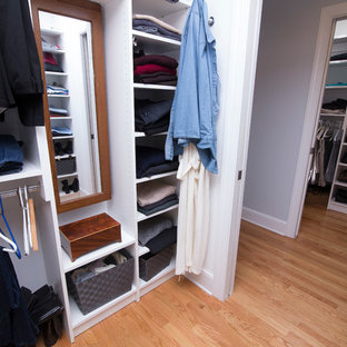 Idee per una cabina armadio unisex chic di medie dimensioni con ante in stile shaker, ante bianche, pavimento in legno massello medio e pavimento arancione