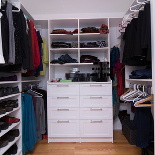 Ispirazione per una cabina armadio unisex chic di medie dimensioni con ante in stile shaker, ante bianche, pavimento in legno massello medio e pavimento arancione