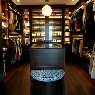 Imagen de armario vestidor unisex, tradicional renovado, de tamaño medio, con armarios abiertos, puertas de armario de madera en tonos medios y suelo de madera oscura