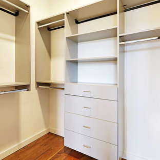 Ispirazione per una cabina armadio unisex industriale di medie dimensioni con pavimento in legno massello medio e pavimento marrone