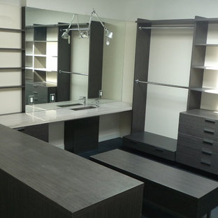 Idee per una grande cabina armadio unisex minimalista con ante lisce, ante grigie, pavimento in legno verniciato e pavimento nero