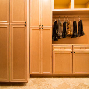 Imagen de armario vestidor unisex, clásico, grande, con armarios con paneles con relieve, puertas de armario de madera clara, suelo de travertino y suelo beige