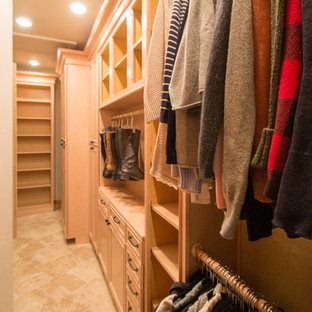 Modelo de armario vestidor unisex, tradicional, grande, con armarios con paneles con relieve, puertas de armario de madera clara, suelo de travertino y suelo beige