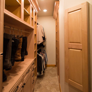 Diseño de armario vestidor unisex, tradicional, grande, con armarios con paneles con relieve, puertas de armario de madera clara, suelo de travertino y suelo beige