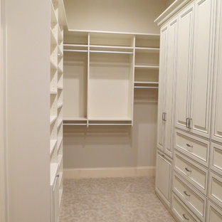 Esempio di una grande cabina armadio per donna chic con ante con finitura invecchiata, moquette, ante con riquadro incassato e pavimento beige