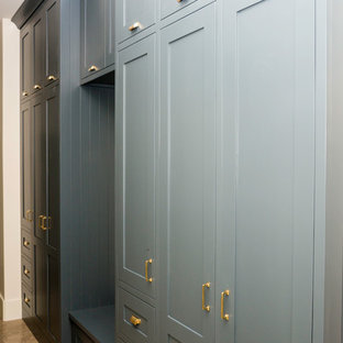 Idee per una cabina armadio unisex classica di medie dimensioni con ante in stile shaker, ante blu, pavimento in travertino e pavimento marrone
