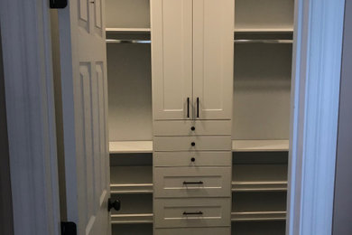 Modelo de armario vestidor unisex de estilo de casa de campo de tamaño medio con armarios estilo shaker, puertas de armario blancas, moqueta y suelo gris