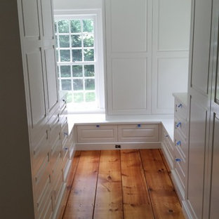 Imagen de armario vestidor unisex, campestre, grande, con puertas de armario blancas y suelo de madera en tonos medios