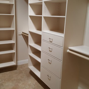 Imagen de armario vestidor unisex, actual, grande, con armarios con paneles lisos, puertas de armario blancas y suelo de travertino