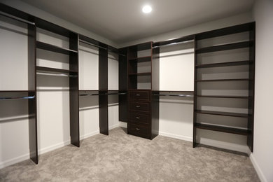 Large trendy gender-neutral carpeted walk-in closet photo in Orlando with open cabinets and dark wood cabinets
