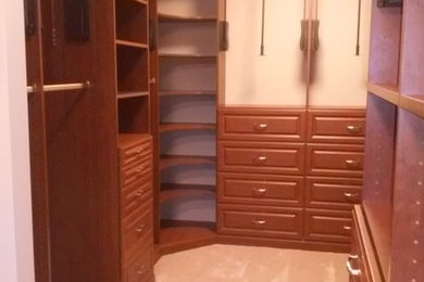 Diseño de armario vestidor unisex actual de tamaño medio con armarios abiertos, puertas de armario de madera oscura, moqueta y suelo beige