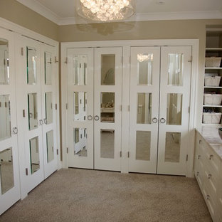Modelo de vestidor unisex, tradicional renovado, de tamaño medio, con armarios con paneles con relieve, puertas de armario beige, moqueta y suelo beige