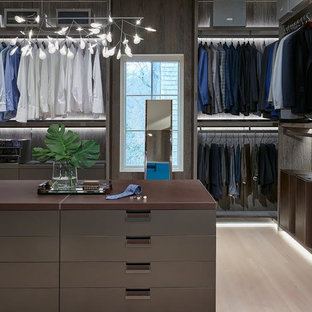 Modelo de vestidor de hombre, actual, extra grande, con armarios con paneles lisos, puertas de armario marrones, suelo de madera clara y suelo beige