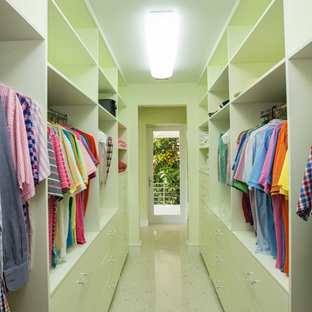 Esempio di armadi e cabine armadio unisex tropicali con ante lisce, ante verdi e pavimento in travertino