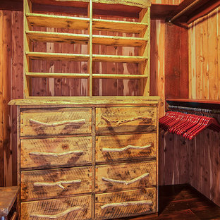 Esempio di una cabina armadio unisex rustica di medie dimensioni con ante lisce, ante con finitura invecchiata e parquet scuro