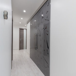 Foto di un armadio o armadio a muro unisex minimalista di medie dimensioni con ante di vetro, ante grigie, pavimento in laminato e pavimento grigio