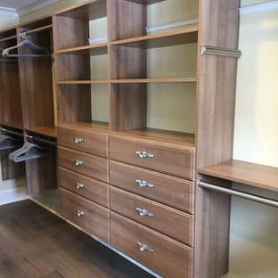 Imagen de armario vestidor unisex, bohemio, grande, con puertas de armario de madera oscura y suelo de madera en tonos medios