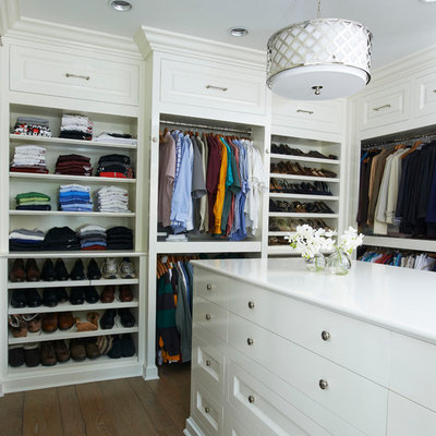 Large elegant gender-neutral dark wood floor and brown floor walk-in closet photo in New York with white cabinets and flat-panel cabinets