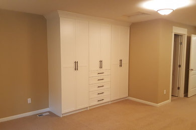 Large trendy gender-neutral dressing room photo in Seattle with shaker cabinets and white cabinets