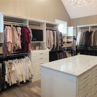 Foto di un'ampia cabina armadio unisex minimal con ante con bugna sagomata, ante bianche, pavimento in vinile e pavimento multicolore