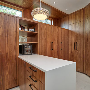 Diseño de armario vestidor unisex, moderno, extra grande, con armarios con paneles lisos, puertas de armario de madera oscura y suelo de baldosas de cerámica