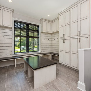 Inspiration för stora lantliga walk-in-closets för könsneutrala, med luckor med infälld panel, skåp i slitet trä, klinkergolv i porslin och brunt golv