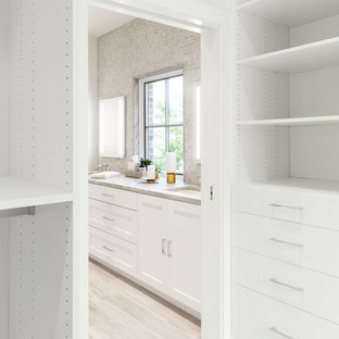 Inspiration för ett stort funkis walk-in-closet för könsneutrala, med släta luckor, vita skåp, kalkstensgolv och beiget golv