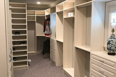 Diseño de armario vestidor unisex clásico grande con armarios con paneles con relieve, puertas de armario blancas, moqueta y suelo gris